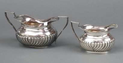 A Victorian silver twin handled sugar bowl with demi-reeded decoration together with a matching