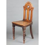 A Victorian bleached mahogany Gothic hall chair with pierced back, solid seat, raised on turned