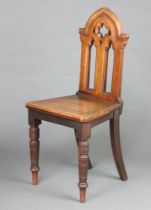 A Victorian bleached mahogany Gothic hall chair with pierced back, solid seat, raised on turned