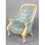 A Victorian bleached mahogany show frame armchair upholstered in turquoise buttoned leather, the