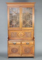 A Victorian carved oak secretaire bookcase with moulded cornice, the shelved interior enclosed by