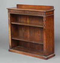 A 1920's carved oak bookcase with raised back fitted adjustable shelves, raised on a platform base