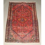 An orange, red and blue ground Persian rug with diamond medallion to the centre 173cm x 109cm Flecks