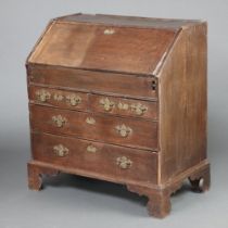 An 18th Century oak bureau, the fall front revealing a stepped interior with well above 2 short