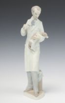 A Lladro figure of a standing veterinary surgeon with dog, the base impressed 10, 34cm