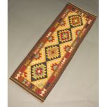 A black, brown, green and tan ground Maimana Kilim runner with 4 diamonds to the centre 196cm x 70cm