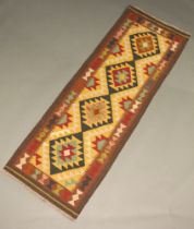 A black, brown, green and tan ground Maimana Kilim runner with 4 diamonds to the centre 196cm x 70cm