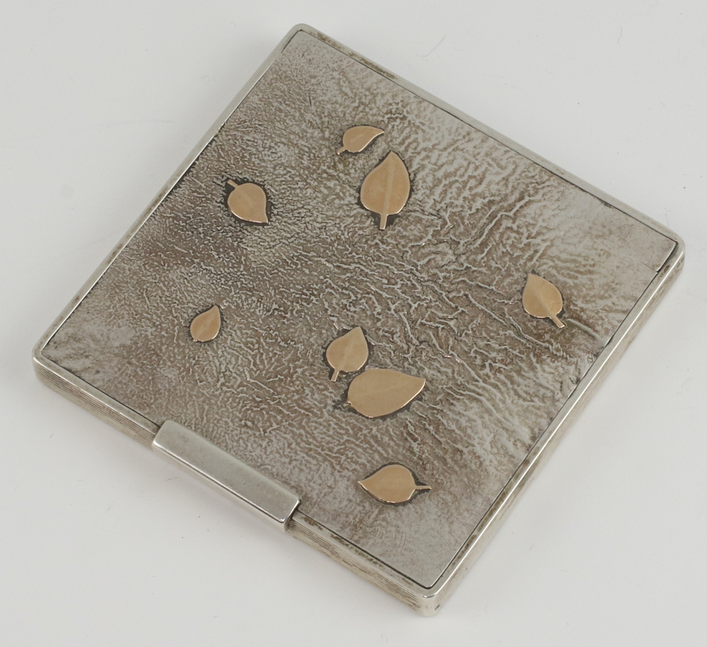 A white metal square compact with leaf decoration 7.5cm x 7.5cm