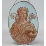 An oval painted glass panel decorated a classical lady feeding birds, contained within a lead