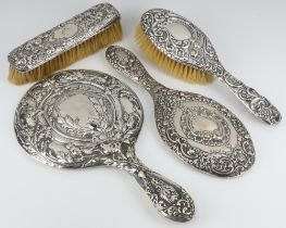 An Edwardian embossed silver backed hand mirror Birmingham 1900 (some holes) together with a