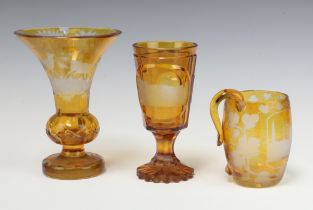 A 19th Century Bohemian amber glass overlay goblet decorated a town scene, raised on a spreading