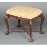 A Queen Anne style rectangular carved mahogany stool raised on cabriole ball and claw supports