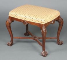 A Queen Anne style rectangular carved mahogany stool raised on cabriole ball and claw supports