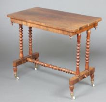 A Victorian rectangular rosewood stretcher table raised on turned supports with bobbin turned H