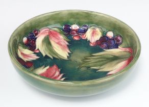 A William Moorcroft green ground bowl with grape and leaf decoration, circa 1930, the base with