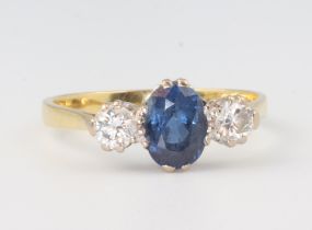 An 18ct yellow gold dress ring set an oval sapphire supported by 2 diamonds, gross weight 3.2g, size