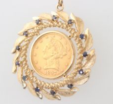 An American 1897 5 dollar coin set in a yellow metal pendant mount with sapphires, gross weight 20.8