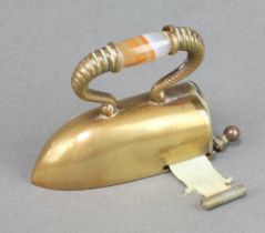 A Victorian novelty gilt metal tape measure in the form of a flat iron with a polished hardstone