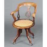 A Victorian bleached mahogany tub back office chair with circular woven cane seat raised on outswept