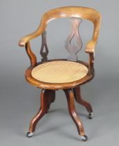 A Victorian bleached mahogany tub back office chair with circular woven cane seat raised on outswept