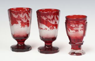 A Bohemian etched red glass goblet with panels decorated stags and hound 12cm (light chips to rim)