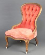 A Victorian bleached mahogany show frame nursing chair upholstered in pink buttoned material, raised