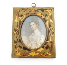 An early 20thC watercolour portrait miniature depicting a seated young lady wearing a three strand