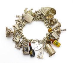 A silver charm bracelet set with various silver and white metal charms to include goat, dog,