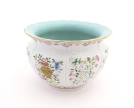 A Chinese famille rose bowl with scalloped edge decorated with flowers, foliage and scrolls.