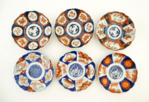 Six assorted Japanese plates with scalloped edges decorated in the Imari palette with flowers,