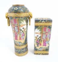 A Chinese vase with twin elephant mask and ring handles decorated with figures with fans on a garden