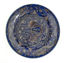 A Chinese charger with blue ground decorated with dragons, flaming pearls and stylised clouds.