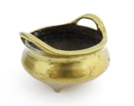 A Chinese cast twin handled censer raised on three feet. Character marks under. Approx. 2 1/2"