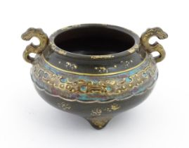 A small Chinese censer with twin handles with banded decoration in relief depicting stylised dragons