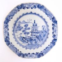 A Chinese export blue and white plate depicting a river landscape scene with pagoda style buildings,