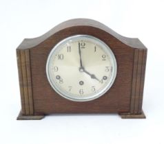 An Art Deco oak cased mantle clock by Garrard. With chiming movement. Approx. 9" high Please