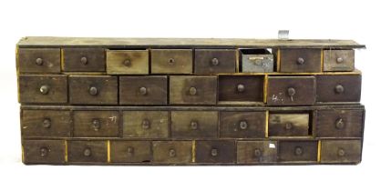 Two rows of haberdashery / apothecary drawers, each set containing fifteen drawers each. 71" long.