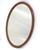 An oval mahogany wall mirror. Approx. 22" tall Please Note - we do not make reference to the
