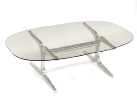 A 20thC coffee table, with elliptical smoky glass top supported by a brushed aluminium frame. In the