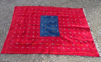 Carpet / Rug: A hand made flat weave wall hanging with central blue ground surrounded by a large red