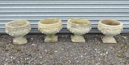 Four matching reconstituted stone pedestal planters with bow and swag detail, each approx 13" tall