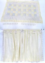 A pair of curtains decorated in a yellow and white check pattern with bow detail. Together with a