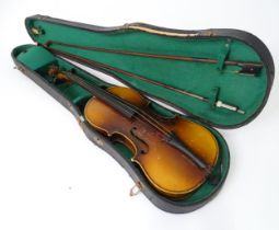 A mid 20thC Bohemian violin, cased with two bows. The instrument approx 23 1/2" long Please Note -