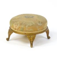 An early 20thC circular footstool raised on four acanthus carved cabriole legs. 12" in diameter x 7"