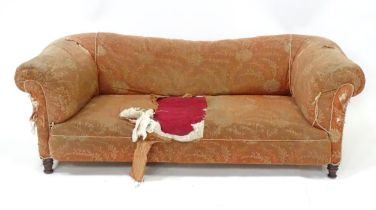 A 19thC two seater Chesterfield sofa, with scrolled arms and standing on four carved feet, approx