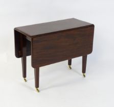 A 20thC mahogany Pembroke table raised on four tapering legs terminating in brass caps and