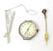 A silver tie clip together with a silver cased watch and a gilt metal stick pin surmounted by enamel