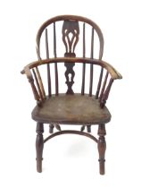 A 19thC Windsor child's armchair with a double-bow stick back and shaped, pierced splat. Standing on