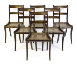 A set of six 19thC brass inlaid dining chairs, with caned seats and drop in seats raised on sabre