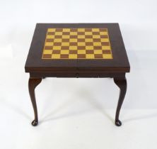 A late 20thC / early 21stC games table with two inlaid playing boards and additional chess pieces